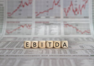 EBITDA word built with letter cubes on newspaper background